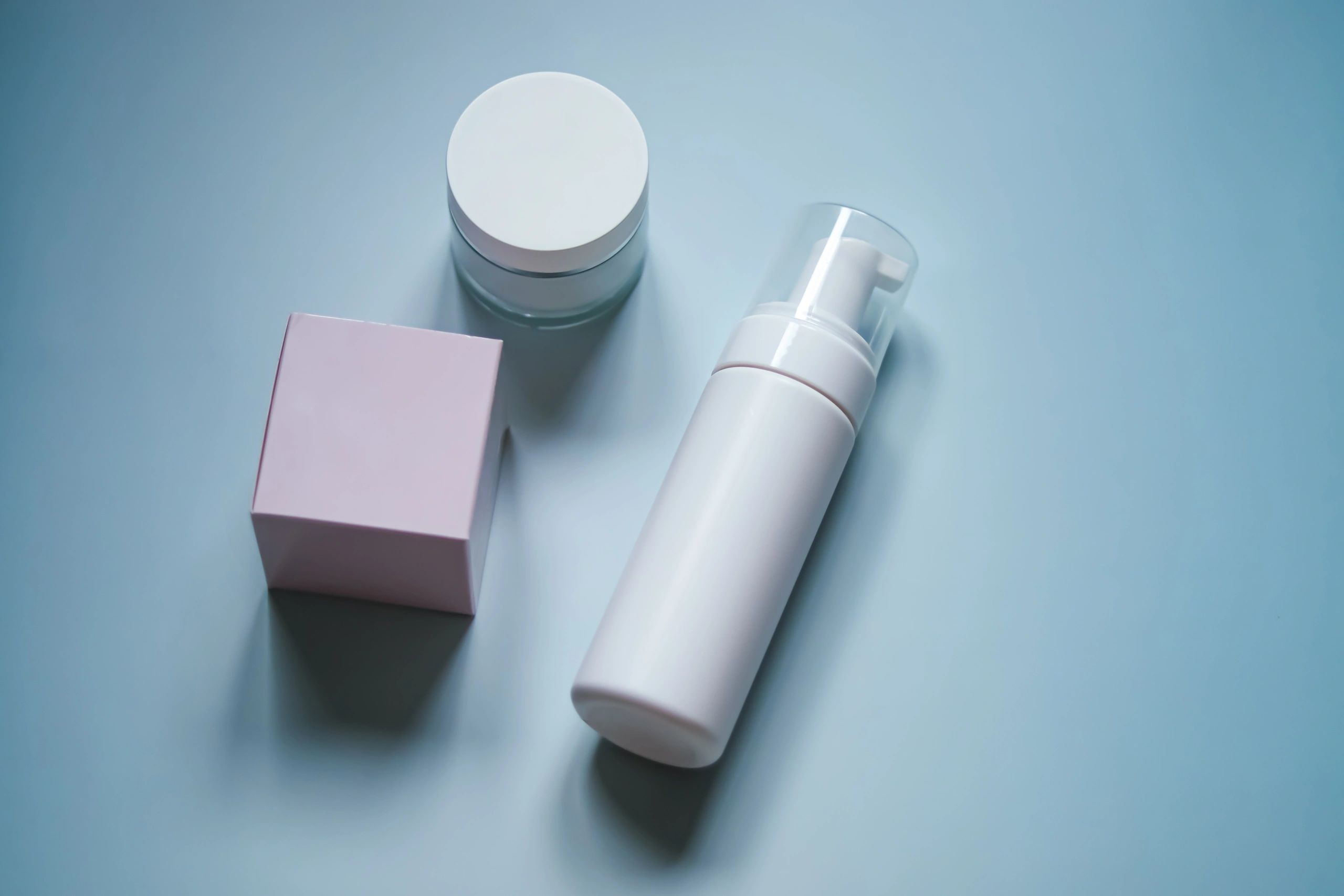 Minimal skincare packaging on a soft pastel background